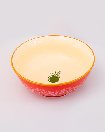top view of cream interior of red large ceramic serving bowl with light pink garden border and orange rim with green veggie inside