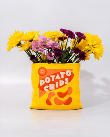 yellow potato chips shaped vase with flowers inside