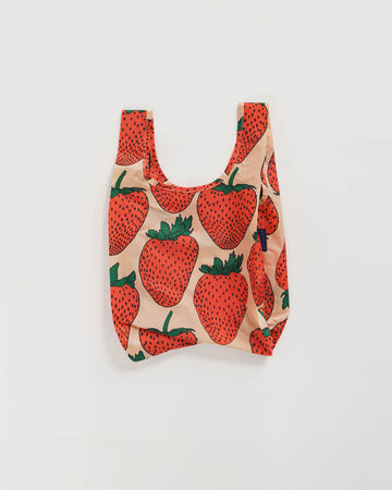 baby baggu in blush pink with large red strawberry pattern