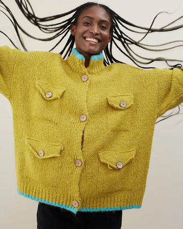 model wearing oversized cardigan with light blue trim and four patch pockets on the front