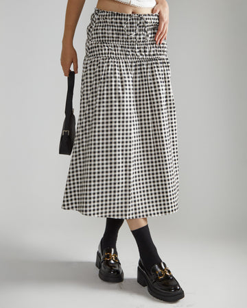 model wearing black and white gingham midi skirt with tie waist and wide smocked waistband