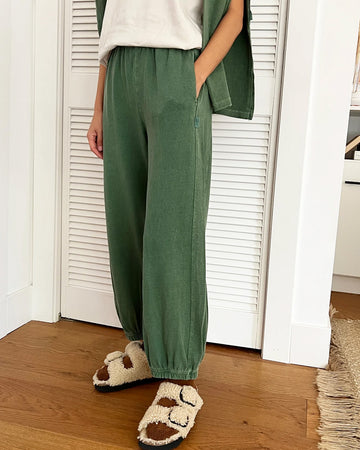 side view of model wearing light green balloon pants with elastic bottoms