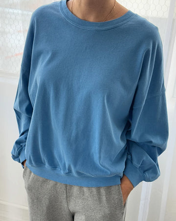model wearing yacht blue cali jersey sweatshirt with banded sleeves and bottom hem