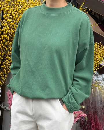 model wearing light green long sleeve top with mock neck neckline and elastic sleeve cuffs and bottom