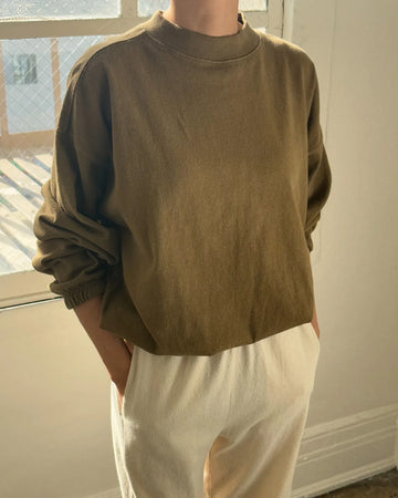 model wearing brown long sleeve top with mock neck neckline and elastic sleeve cuffs and bottom