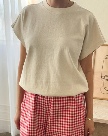model wearing naturel tee with slight cap sleeves, relaxed fit, and banded bottom