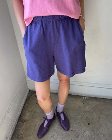 model wearing eggplant purple cotton shorts with elastic waist and side pockets