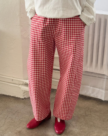 model wearing red and white gingham arc pants with elastic waist, pockets, and barrel legs