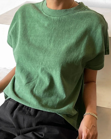 model wearing light green relaxed tee with muscle tee sleeves and side vents at the hem