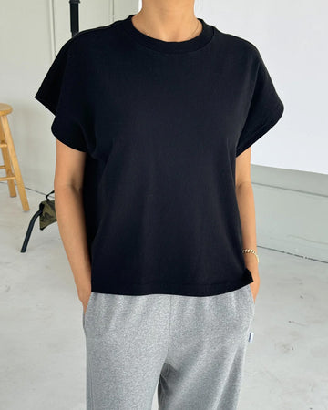 model wearing black relaxed tee with muscle tee sleeves and side vents at the hem