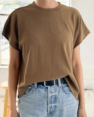 model wearing brown relaxed tee with muscle tee sleeves and side vents at the hem