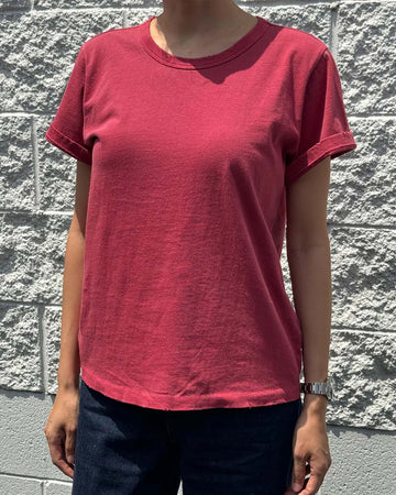 model wearing crayon red organic cotton tee with a vintage look and slight distressing on the neckline and arm holes