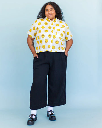 model wearing black relaxed straight leg linen pants with side pockets and elastic waist