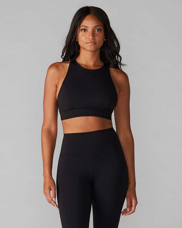 model wearing black high neckline sports bra