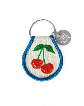 cream patch keychain with cherry print and blue trim
