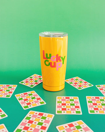 yellow lucky cup thermal mug with playing cards surrounding it