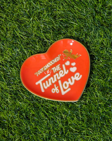 red heart shaped trinket tray that says 'i got smooched at the tunnel of love' in white and metallic gold
